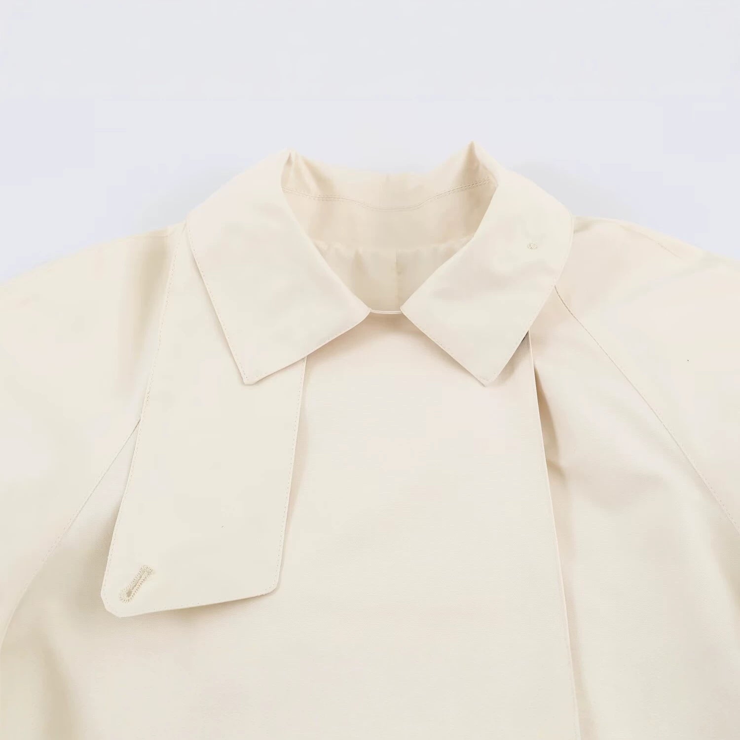 Image of Gabardina asimétrica de mujer en color beige con solapa de botones