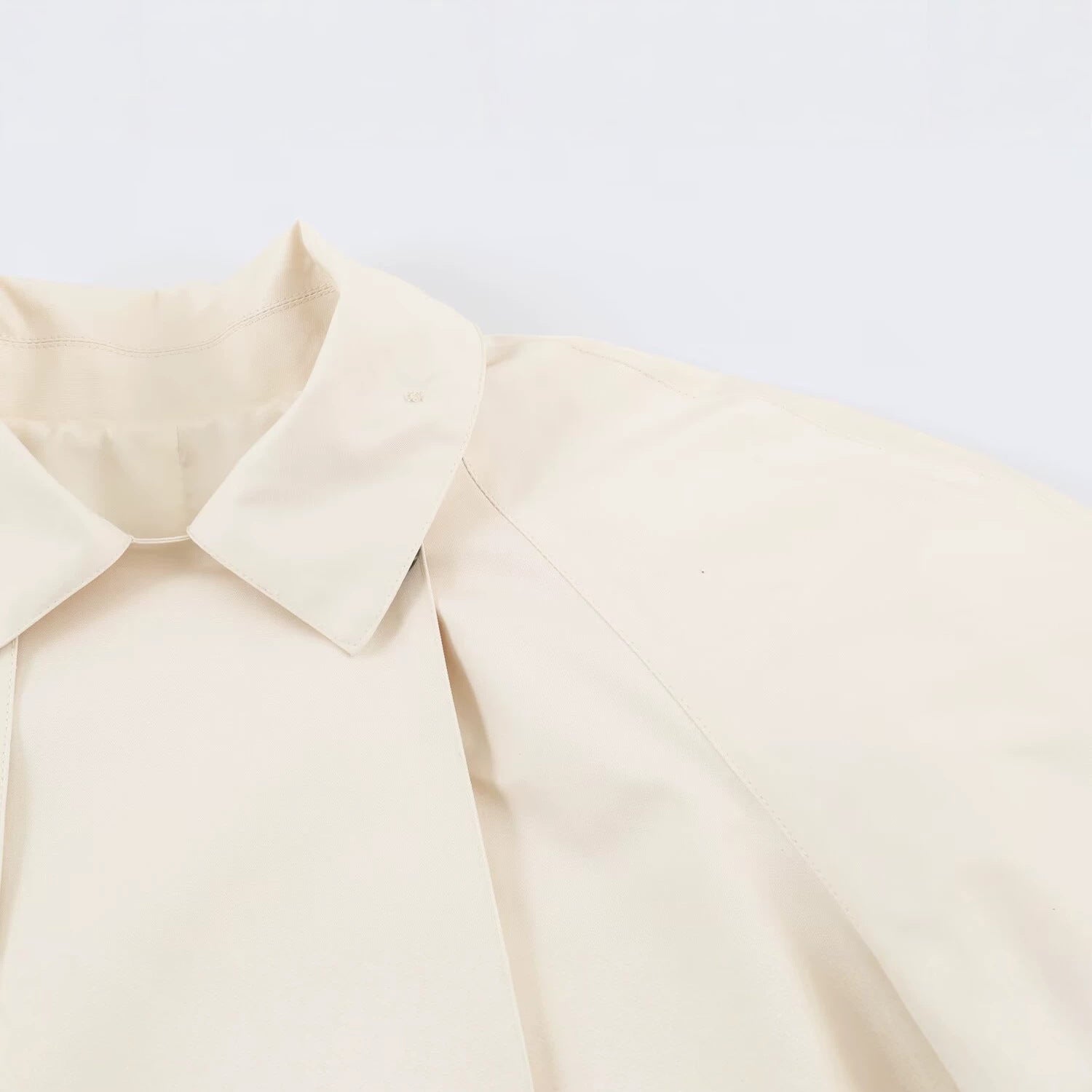 Image of Gabardina asimétrica de mujer en color beige con solapa de botones