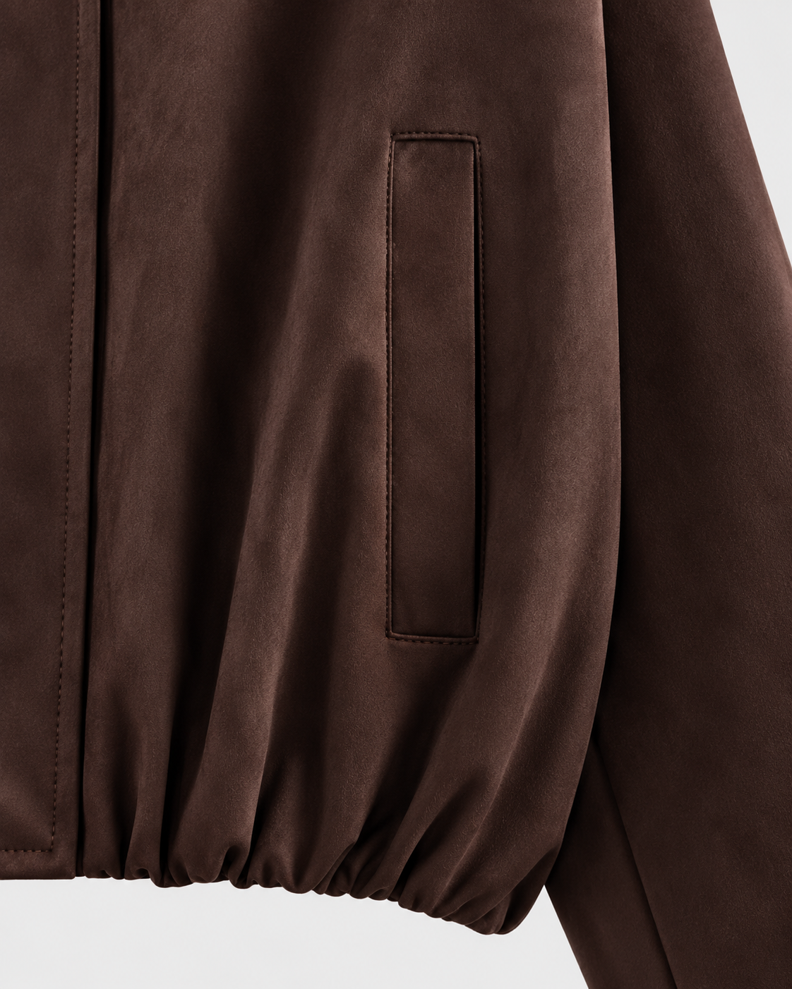 Image of Dark Brown | Close-up of pocket seam and gathered hem on dark brown bomber jacket