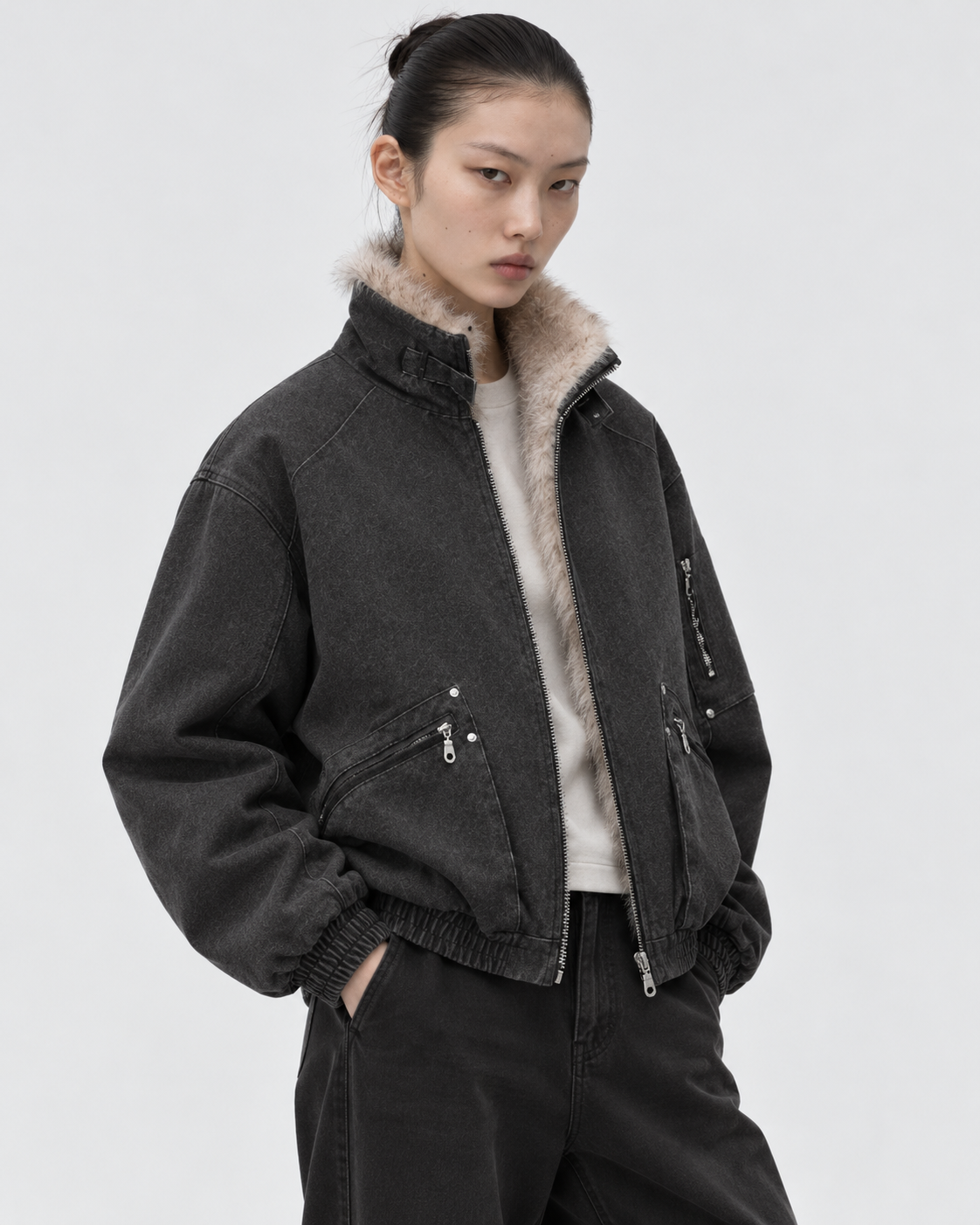 Black | Female model wearing the black zip-up jacket in a second studio pose