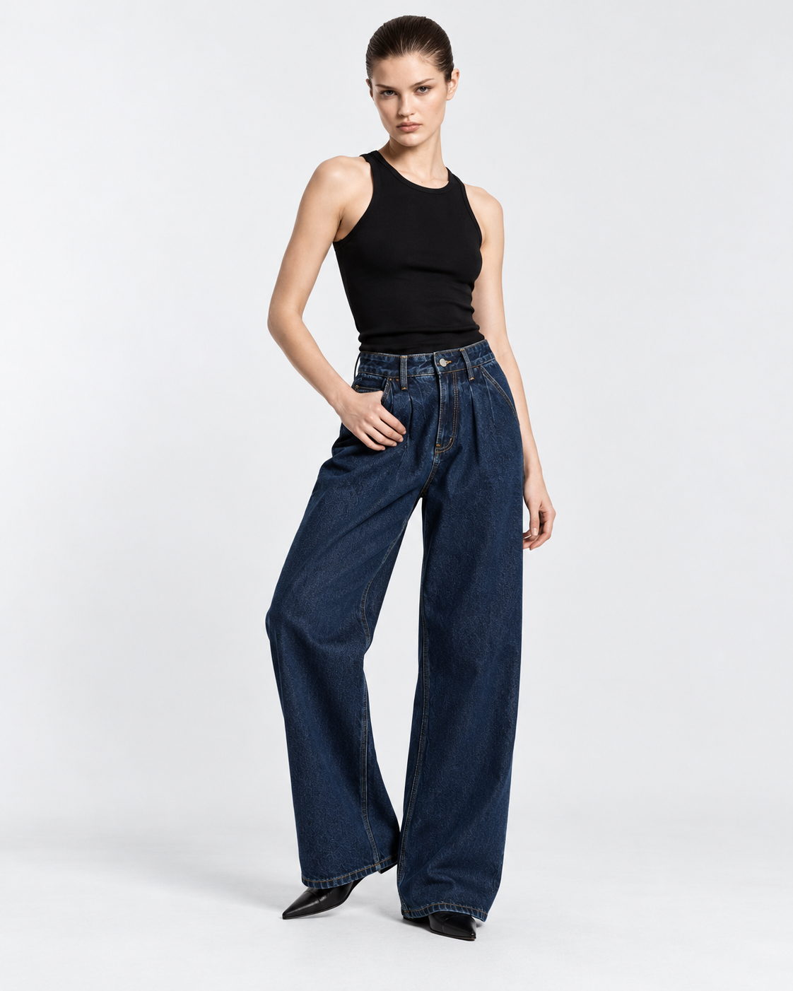 Dark | Model styling dark blue wide-leg jeans in alternate standing pose