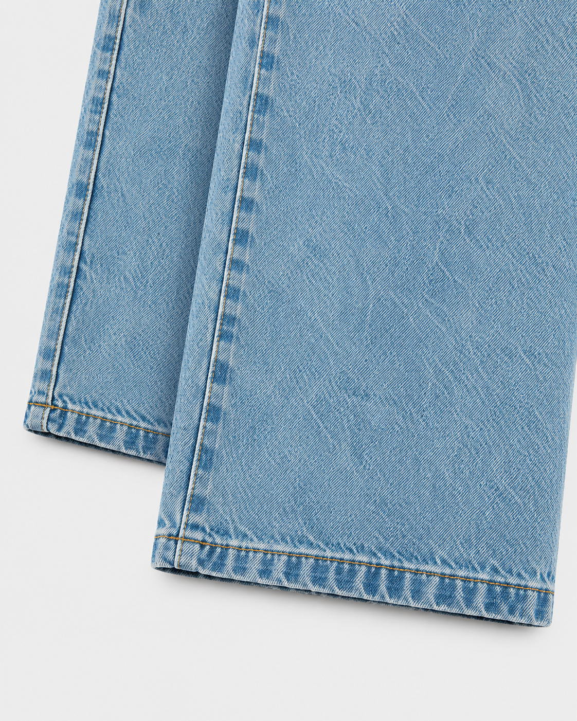 Medium | Close-up of the hem and stitching of medium-blue denim jeans