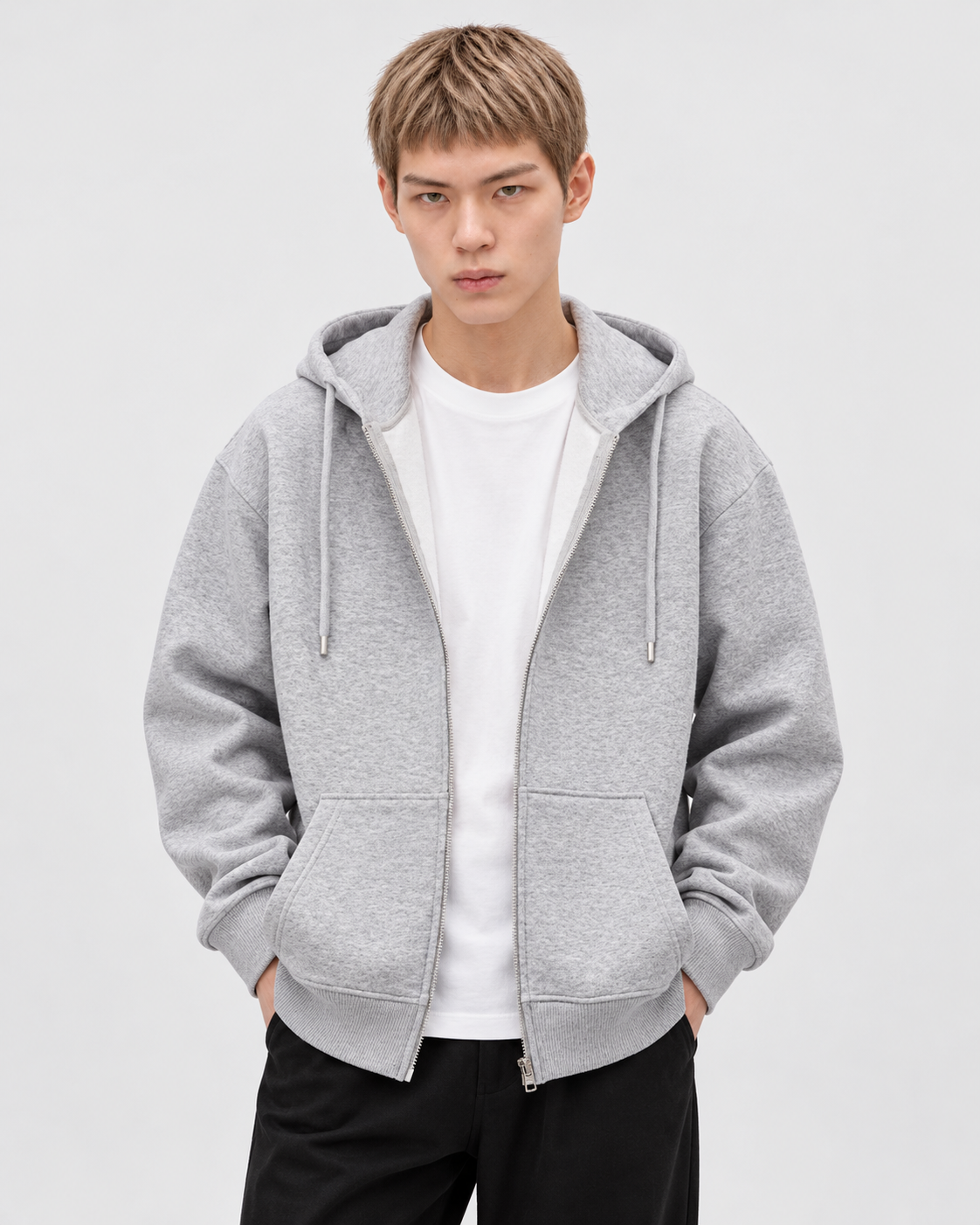 Image of Heather Gray | Male model wearing a heather gray zip-up hoodie over a white T-shirt, front studio pose