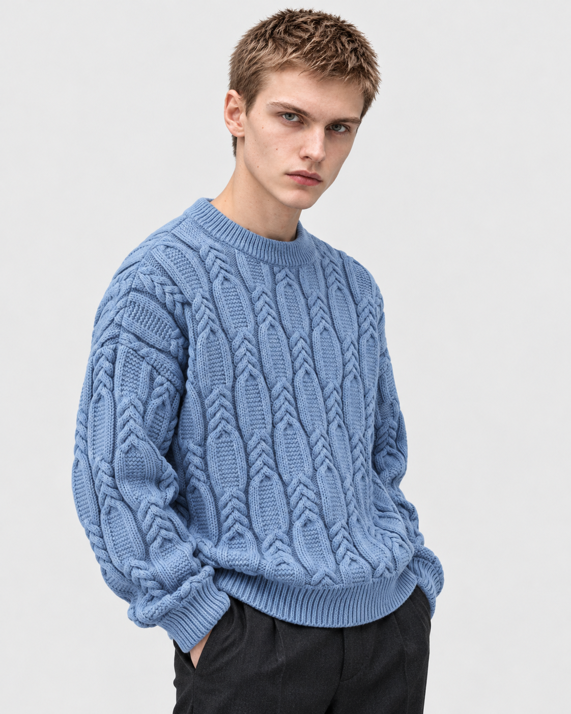 Image of Blue | Model wearing blue cable-knit sweater in three-quarter studio pose