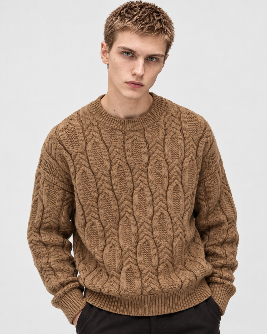 Image of Khaki | Male model wearing a khaki cable-knit crewneck sweater, standing studio pose