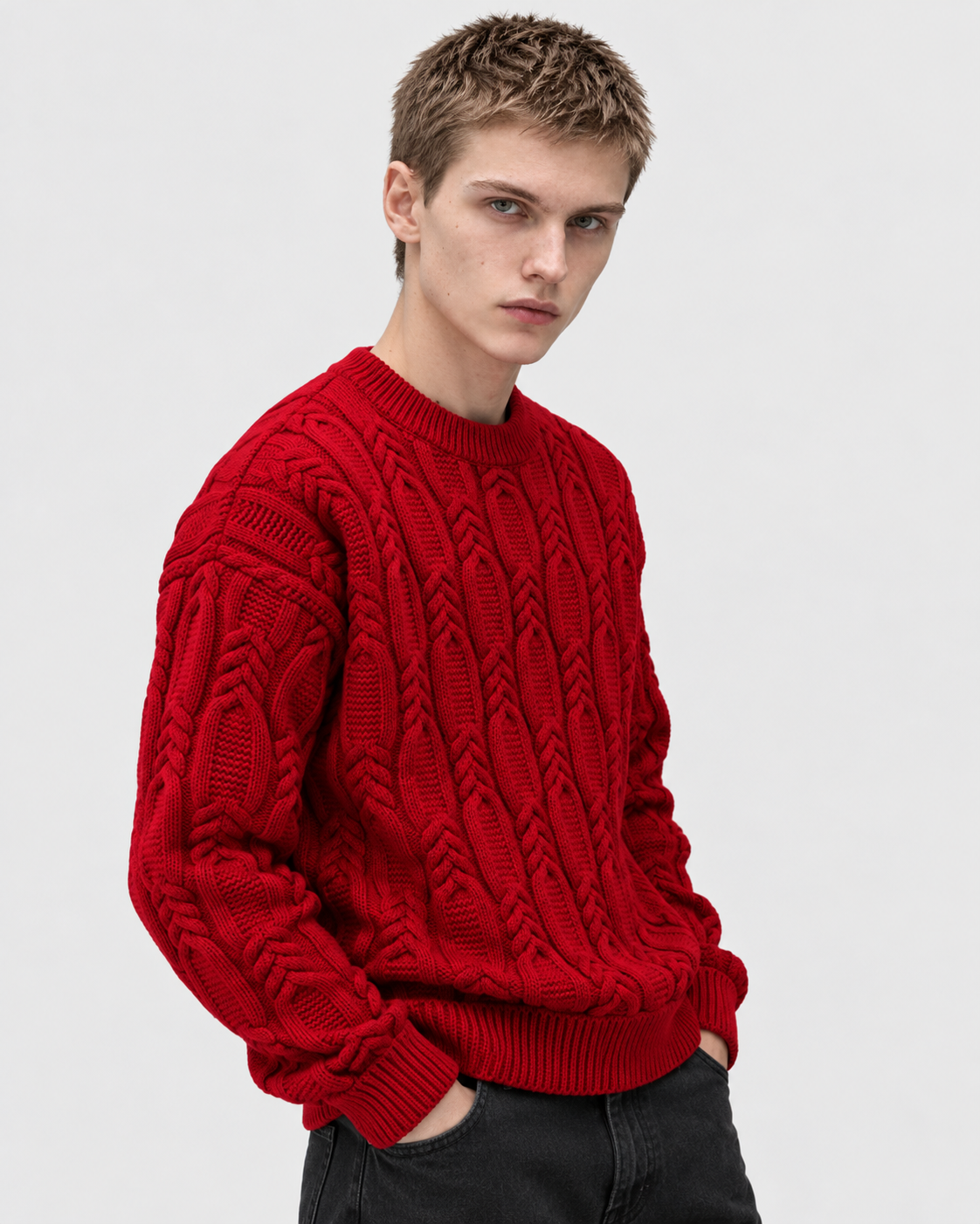Image of Red | Male model wearing bright red cable-knit sweater, side studio pose