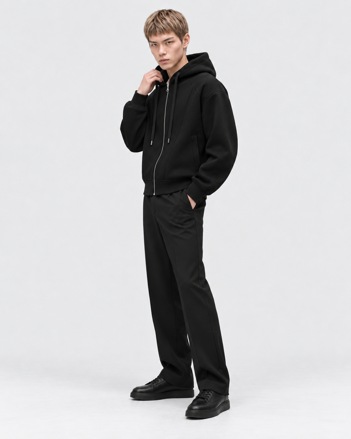 Image of Black | Male model wearing the oversized zip-up hoodie in an alternate studio pose