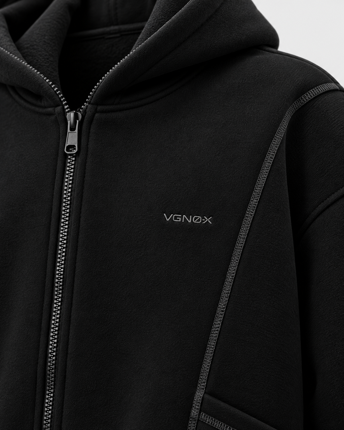 Black | Close-up of the upper chest logo and stitched shoulder panel on the black hooded sweatshirt