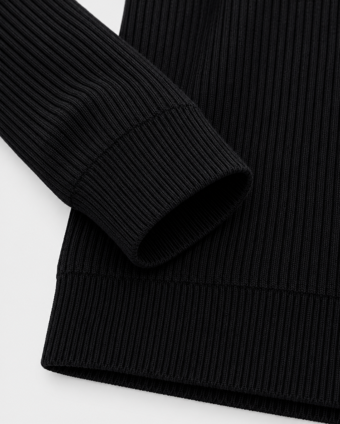 Image of Black | Close-up of the ribbed sleeve cuff and bottom hem on the black turtleneck sweater