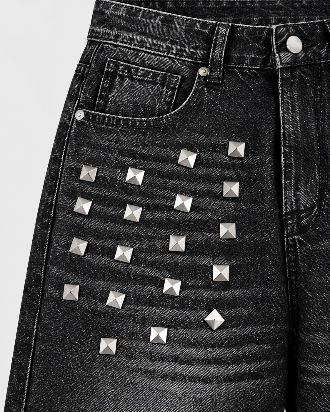Image of Black | Close-up of metallic studs on the upper legs of black washed jeans