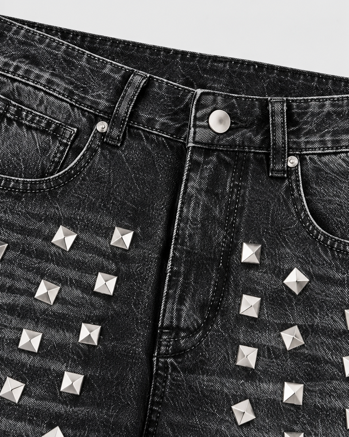 Black | Close-up of front pockets and metallic studs on black washed jeans