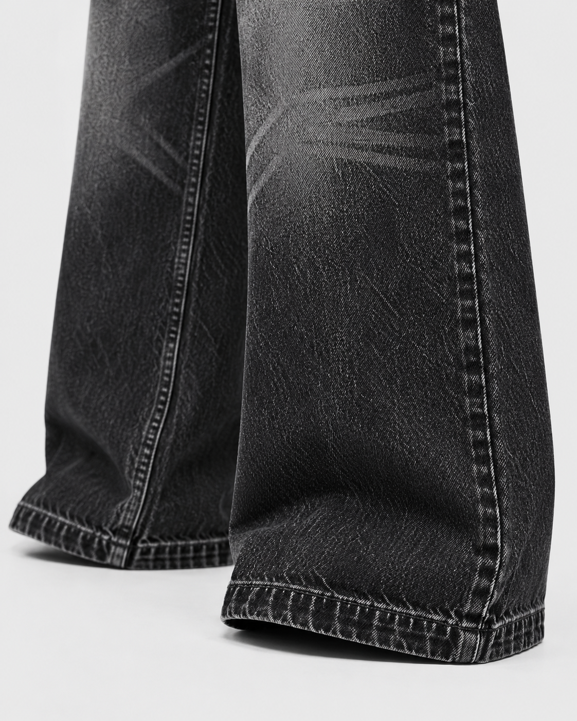 Image of Black | Close-up of stitched hem and faded denim on black straight-leg jeans