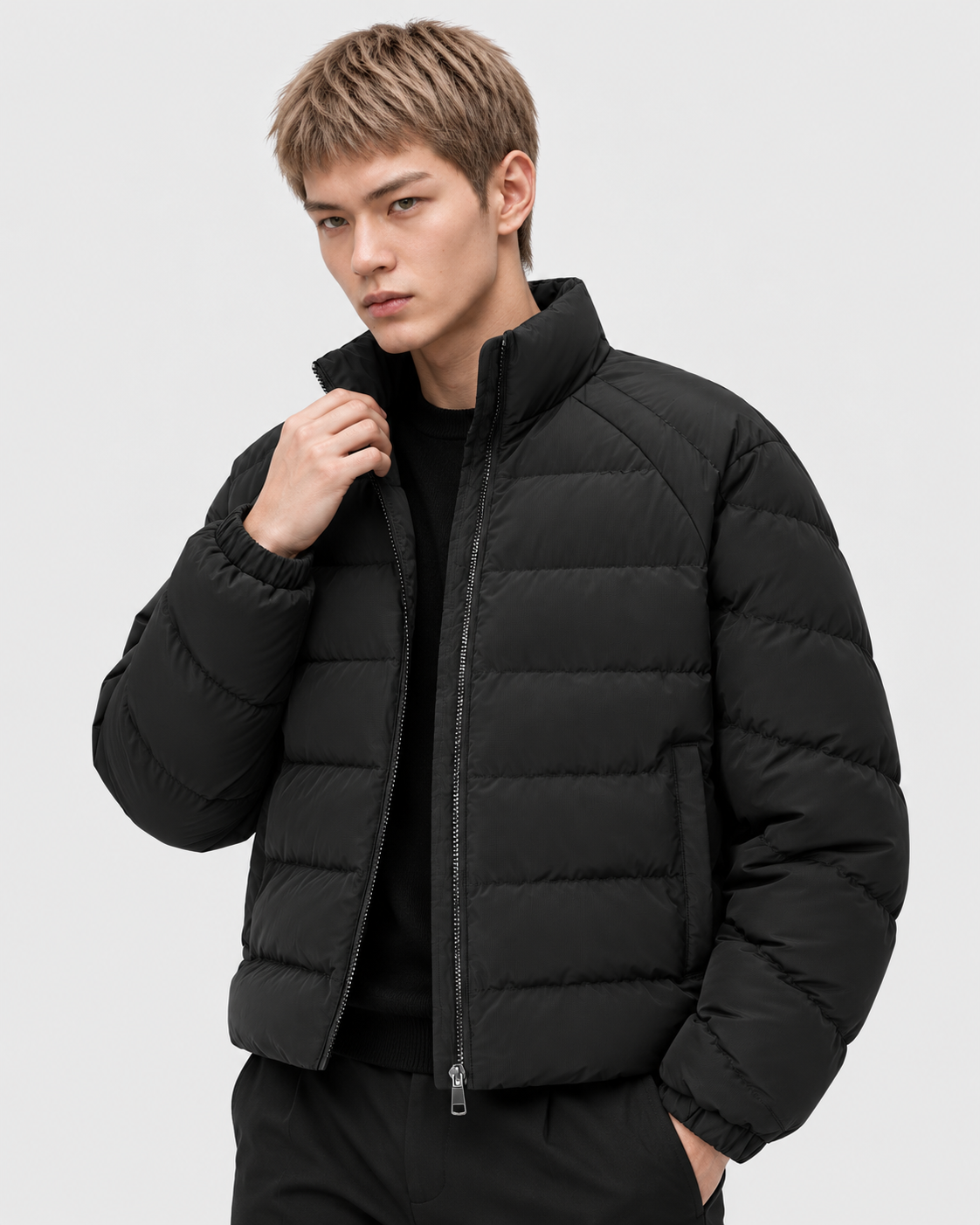 Image of Black | Male model wearing the oversized quilted stand-collar puffer jacket in a standing studio pose
