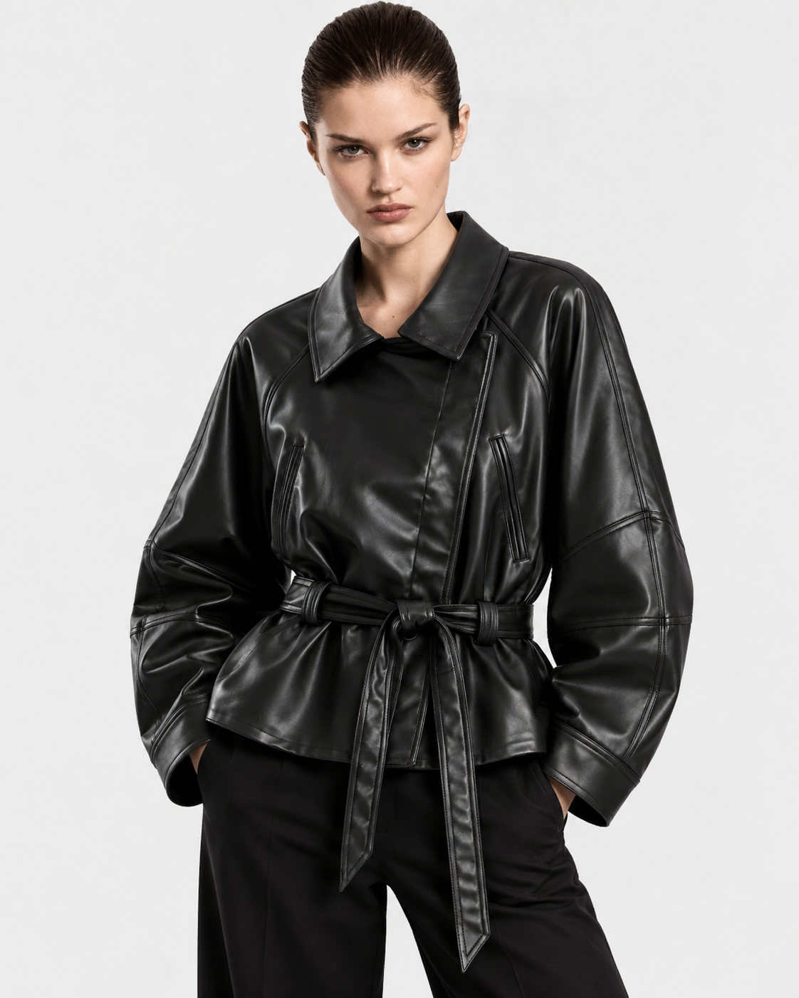 Black | Model wearing women's belted biker-style zip-up jacket, front view