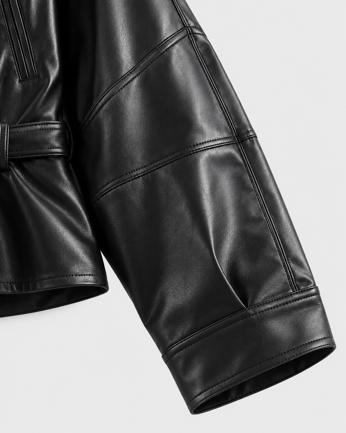 Black | Detail of sleeve seam and stitching on black biker-style jacket