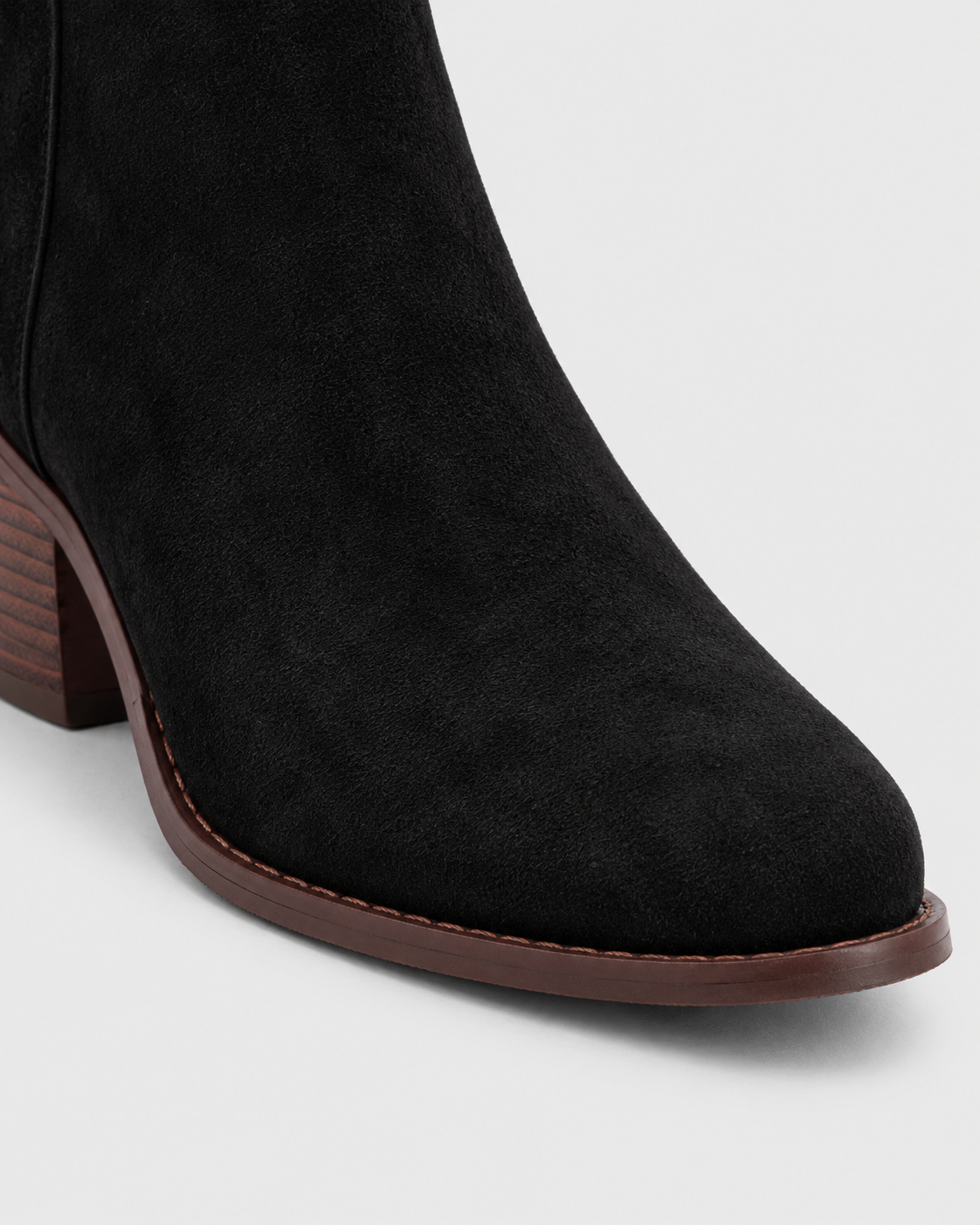 Black | Close-up of tapered pointed toe on black heeled ankle boot