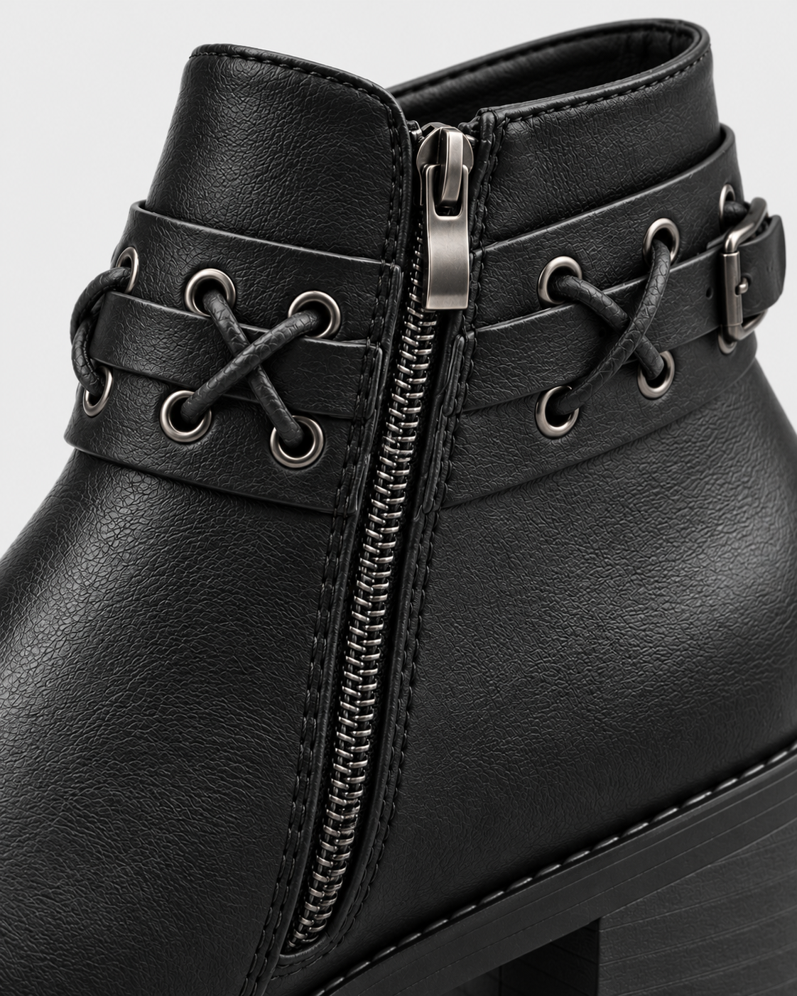 Image of black | Close-up of zipper, buckle and rivet trim on black ankle boot