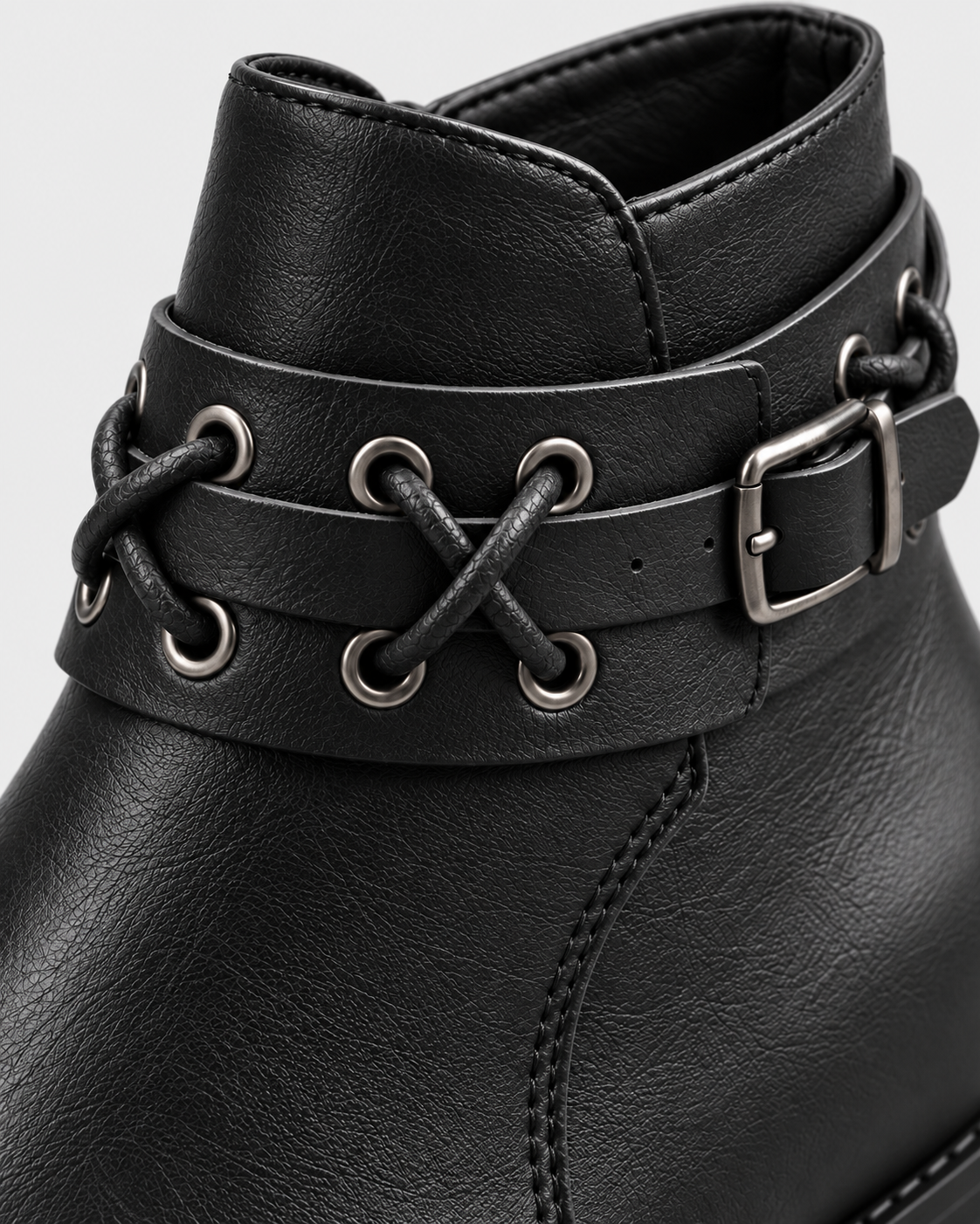 black | Close-up of metallic lace-up rivet strap on black ankle boot