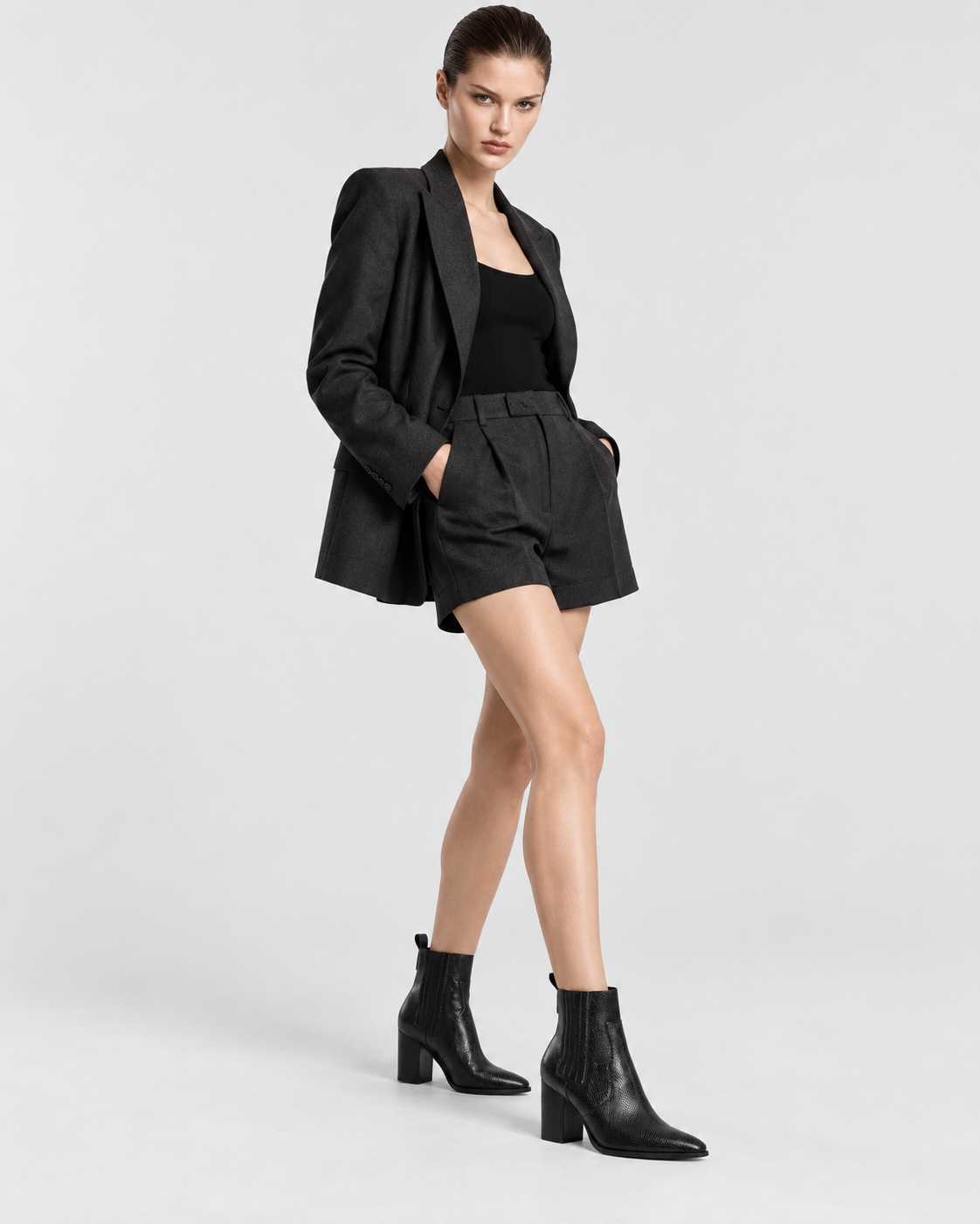 Image of Black | Model standing wearing women's snakeskin-print pointed-toe ankle boots
