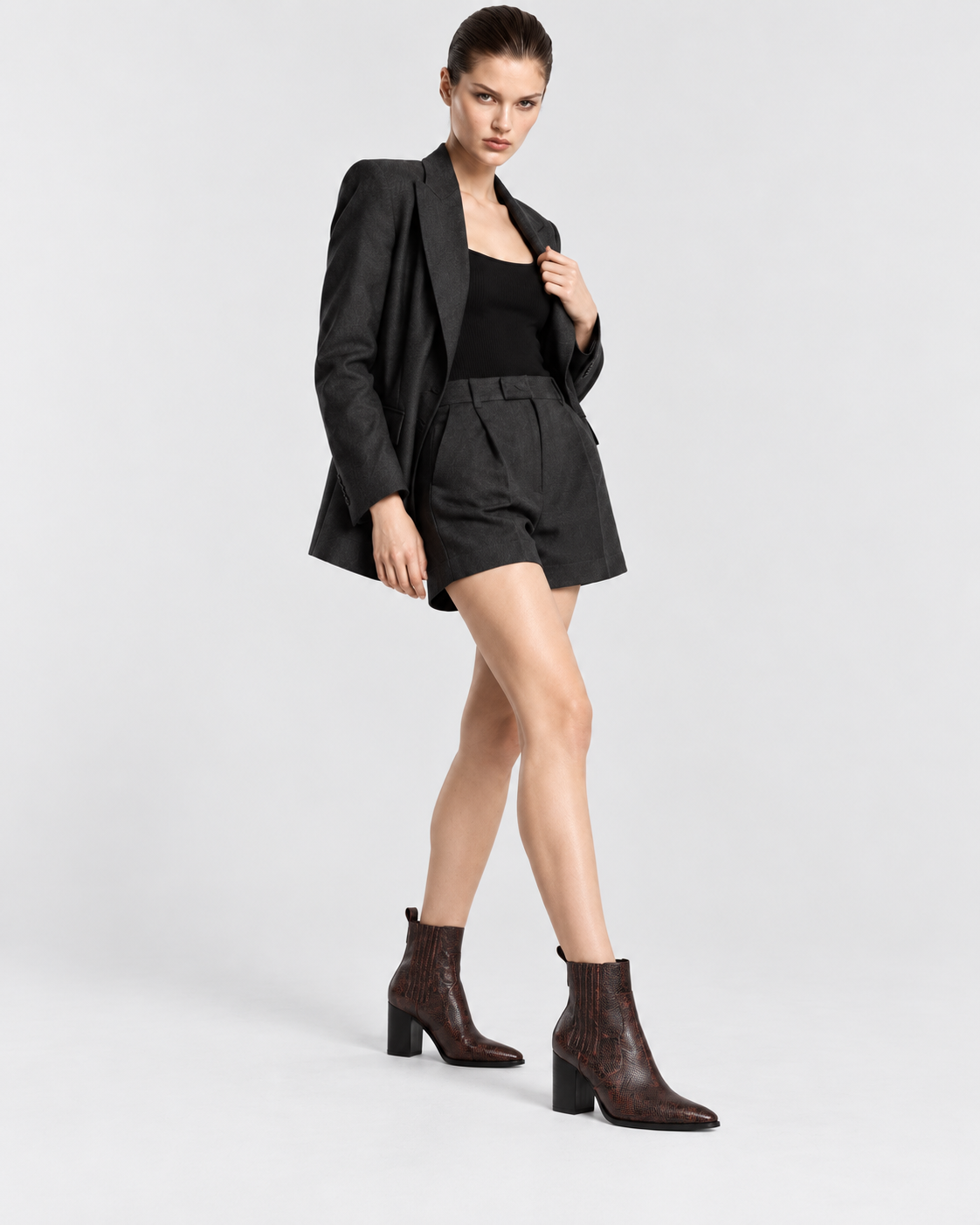 Image of Brown | Model standing wearing brown snakeskin-print pointed-toe ankle boots