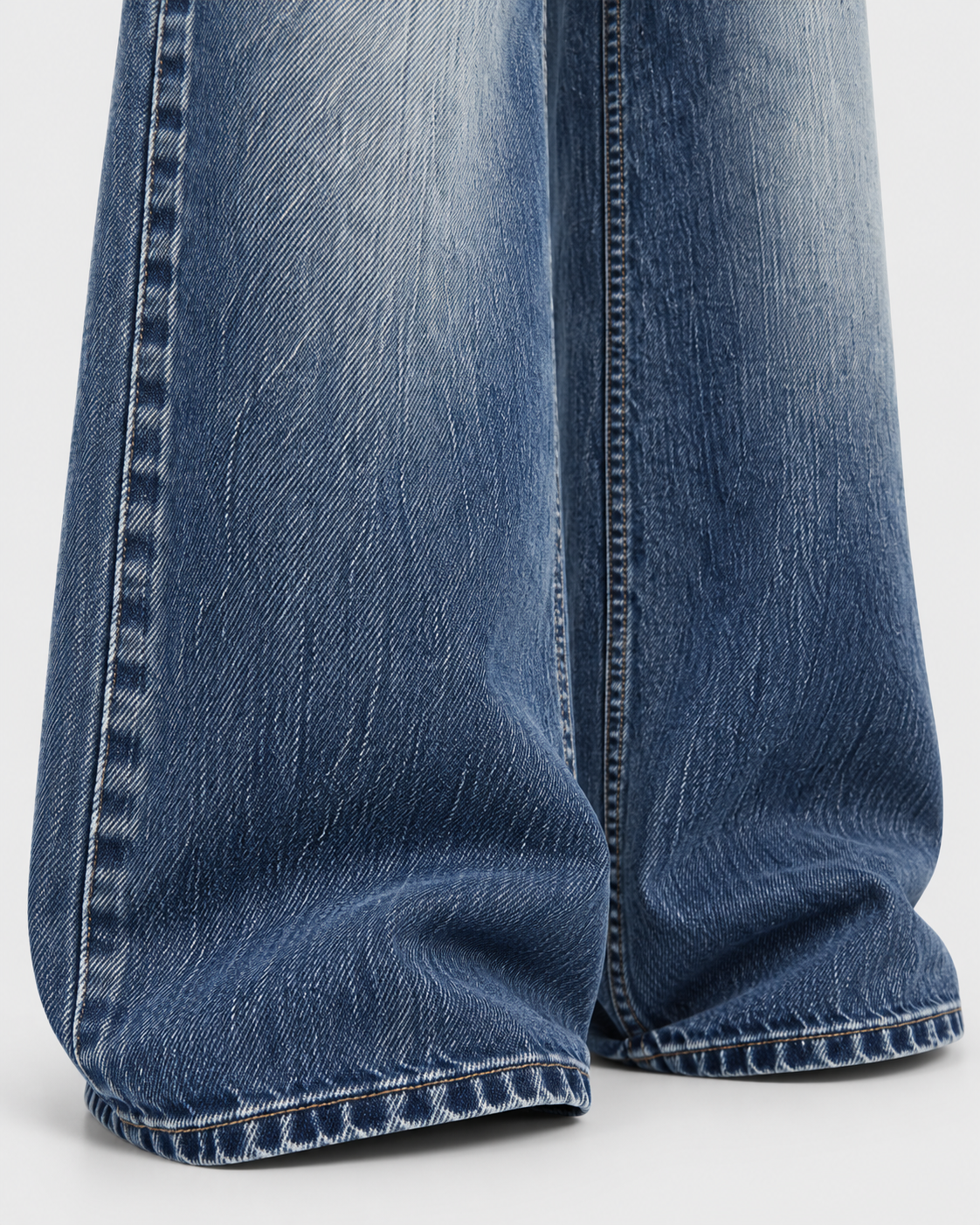 Blue | Close-up of blue washed wide-leg denim hem and stitching