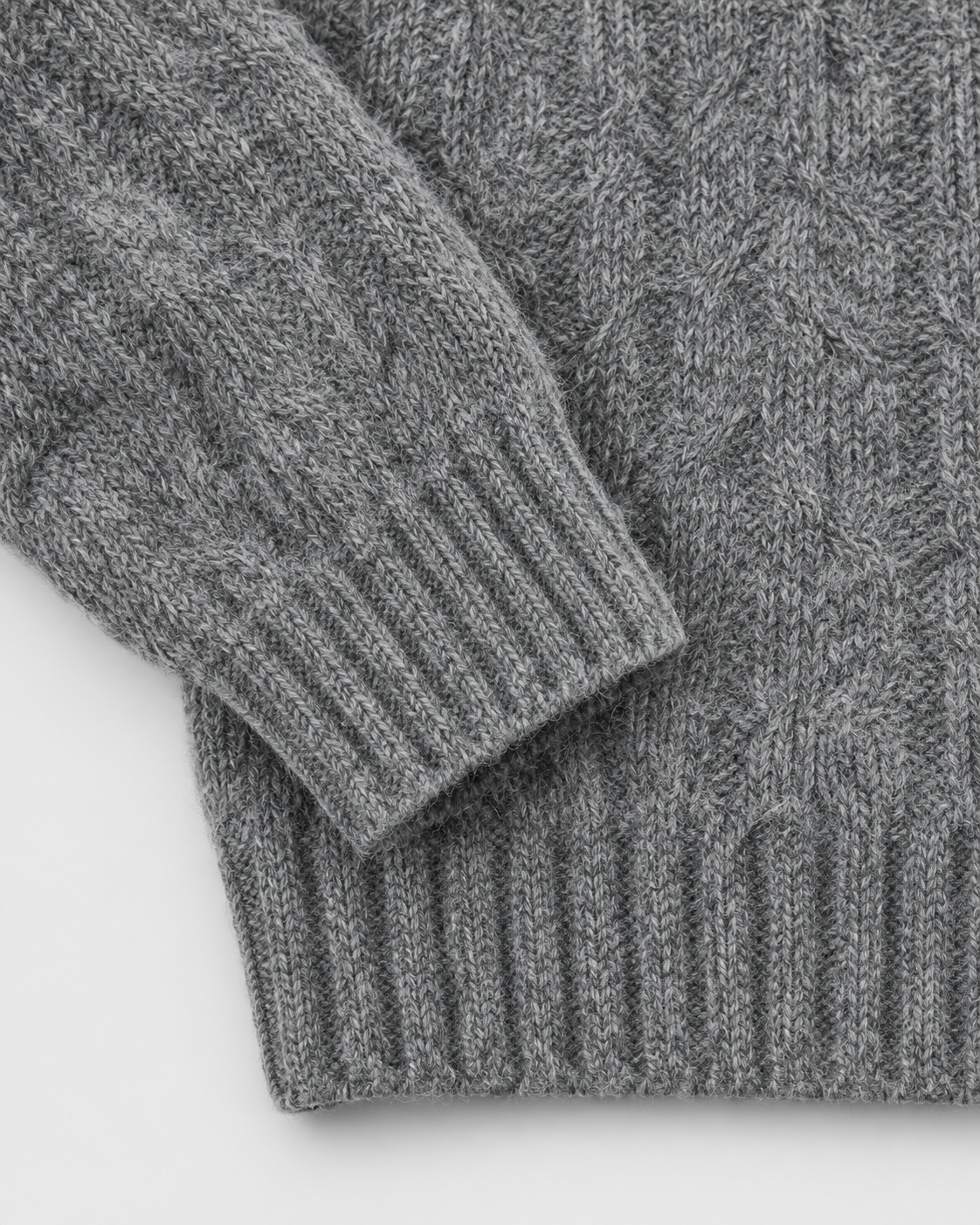 Gray | Close-up of the ribbed cuff and hem on cable-knit sweater