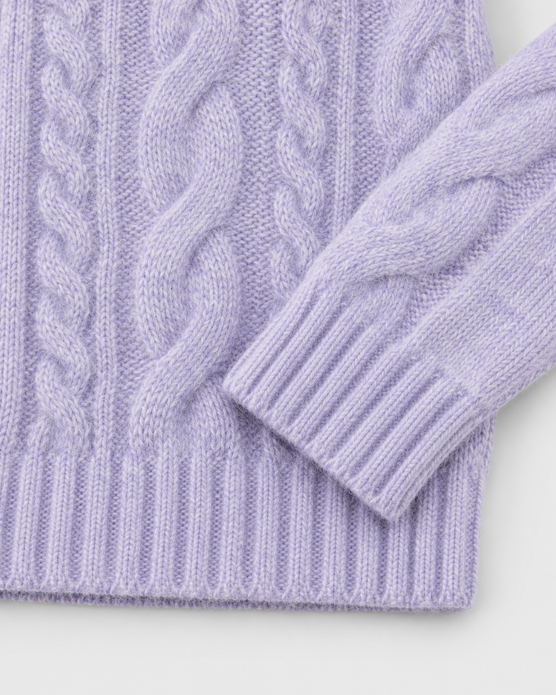 Purple | Close-up of the ribbed cuff and hem on cable-knit sweater