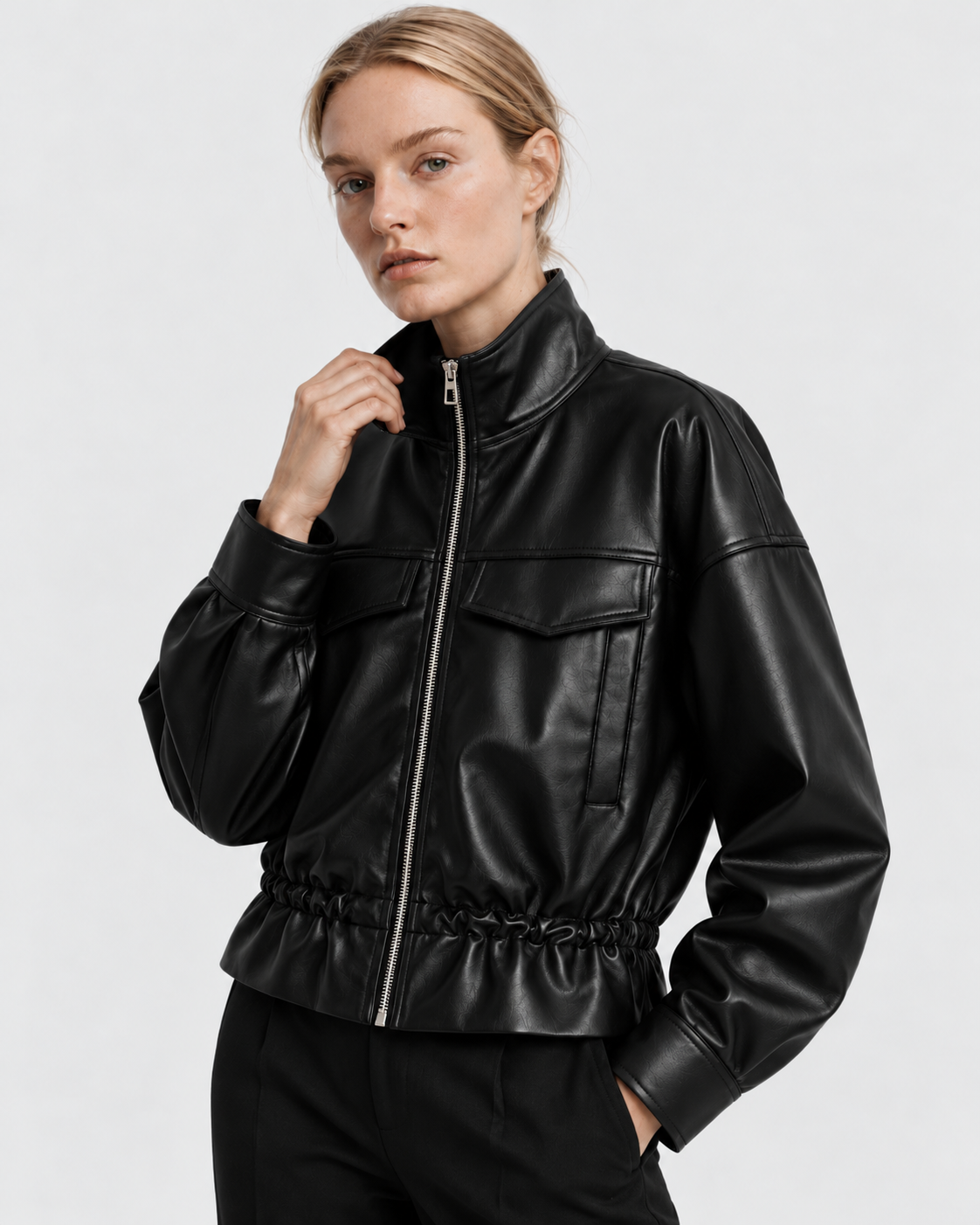 Color: Black | Women's black stand collar faux leather zip-up jacket styled on model, three-quarter view