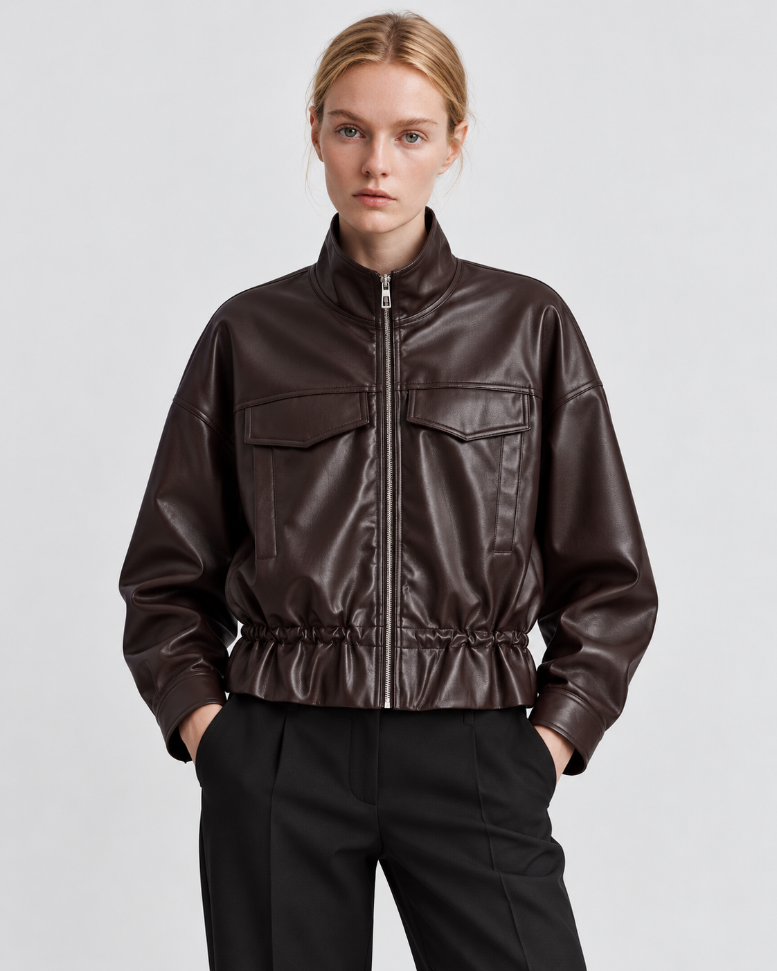 Color: Brown | Women's brown stand collar faux leather zip-up jacket styled on model, front view