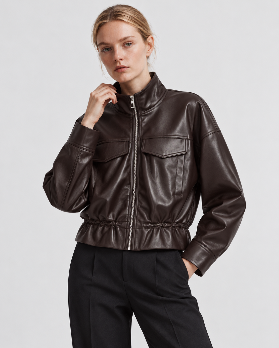 Color: Brown | Women's brown stand collar faux leather zip-up jacket styled on model, three-quarter view